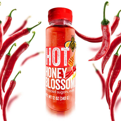 A 12 oz bottle, filled with hot honey surrounded by cayenne peppers
