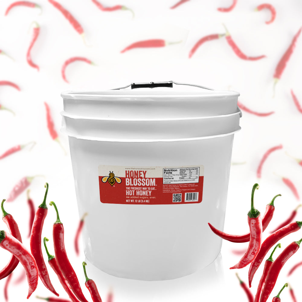 A 12 lb bucket, filled with hot honey, surrounded by cayenne peppers