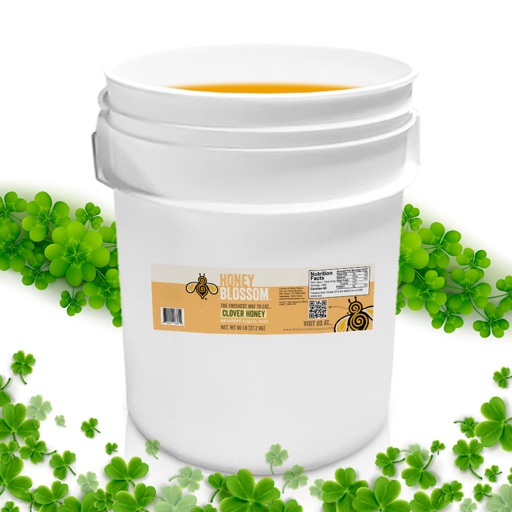 A bucket of white honey that is surrounded by clovers