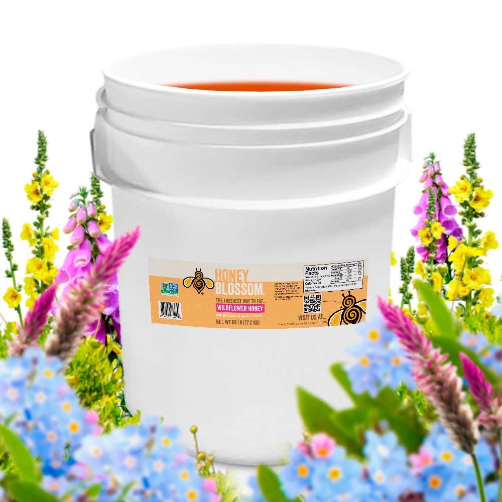 Bucket filled with wildflower honey. With several wildflowers in the background