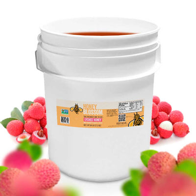 Bucket filled with lychee honey. With several lychee in the background