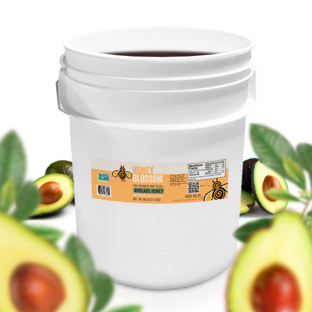 Bucket filled with avocado honey. With several avocados in the background