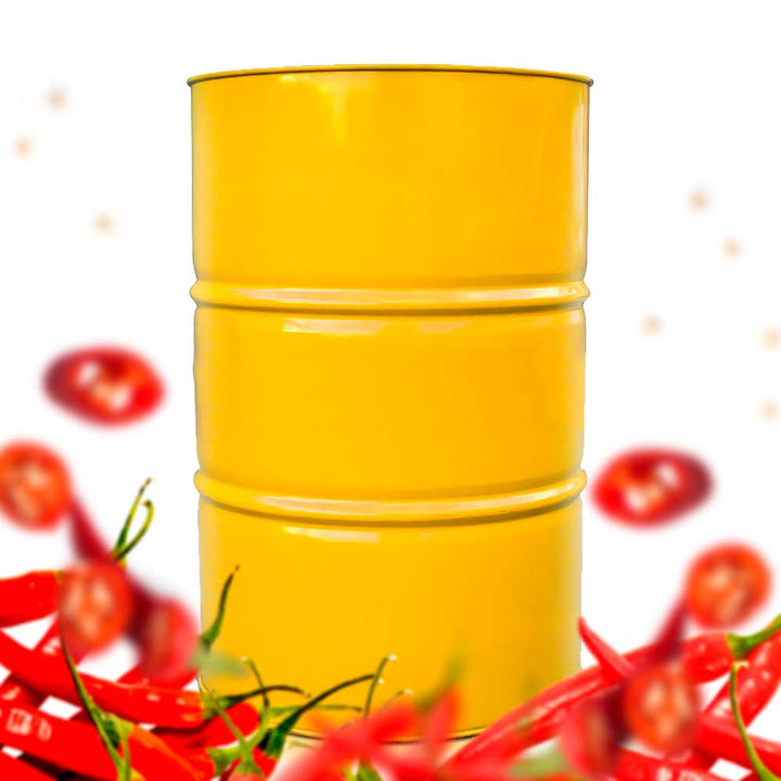A drum, filled with hot honey, surrounded by cayenne peppers