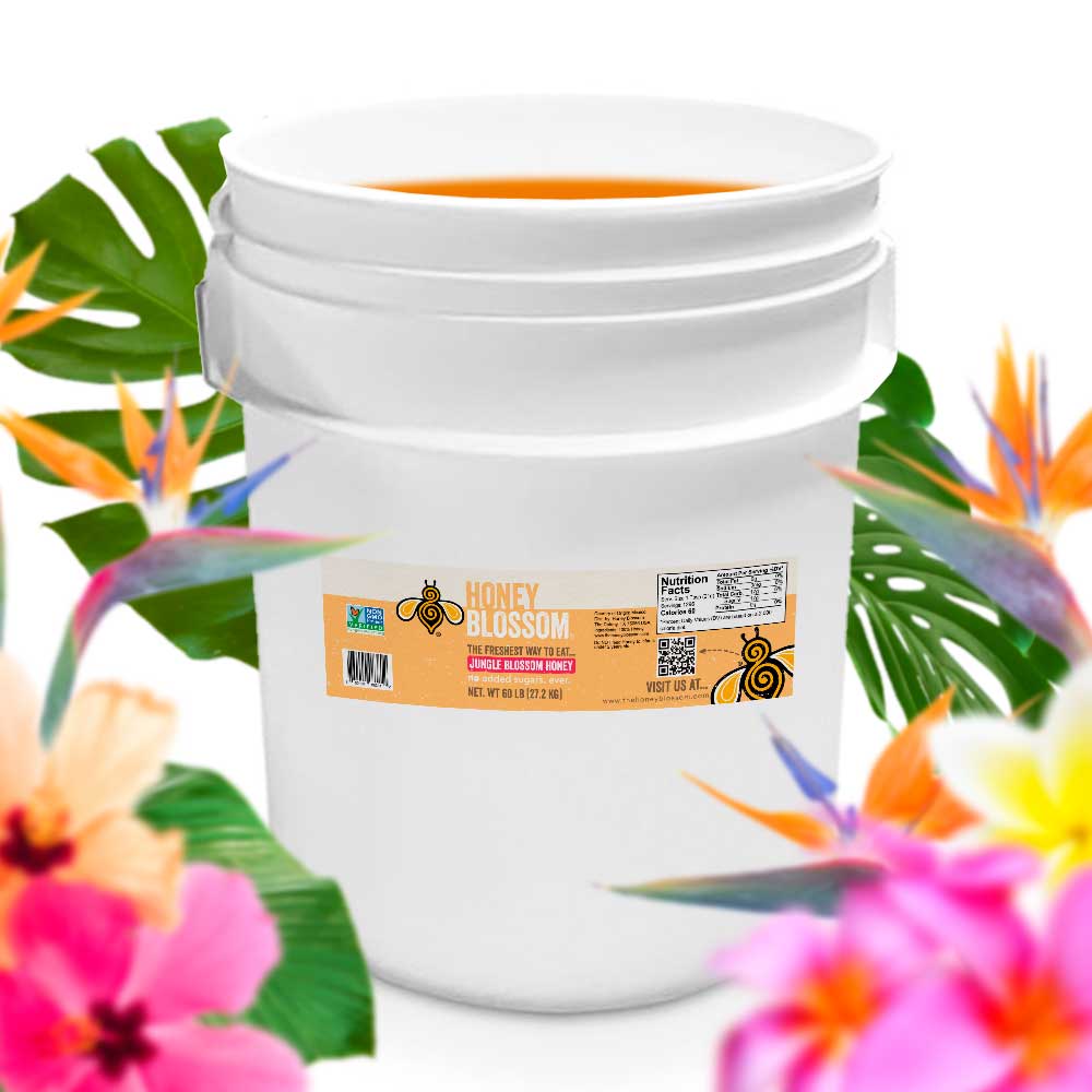 Bucket filled with jungle blossom honey. With several jungle flowers in the background