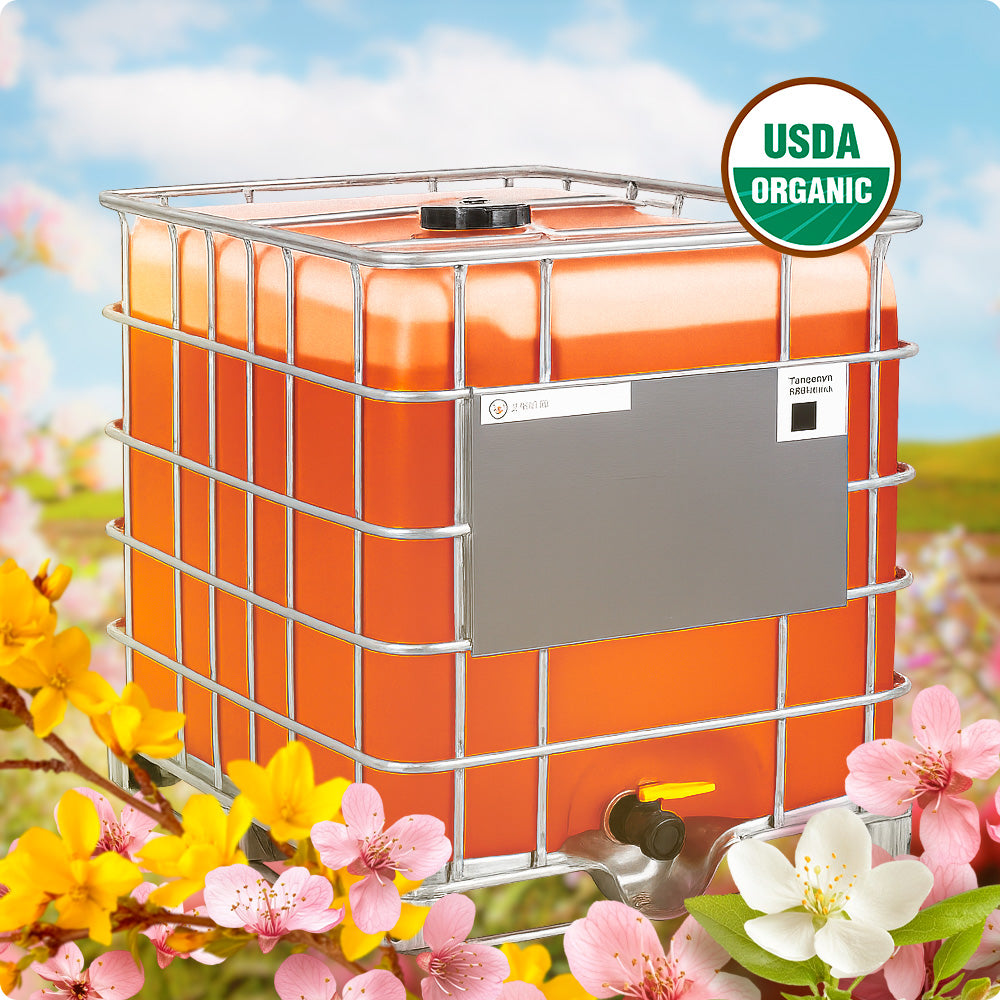 USDA Organic bulk honey IBC tote filled with golden amber honey and surrounded by colorful spring blossoms in a natural landscape.